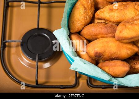 Tartes frietées dorées et savoureuses avec garniture à la maison sur une cuisinière de cuisine. Banque D'Images