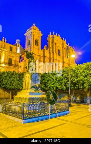 Vue nocturne de la basilique Minore di San Nicolò et du monumento ai caduti della grande guerra à Noto, Sicile, Italie Banque D'Images