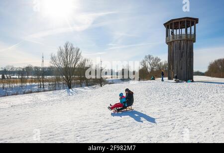 Recklinghausen, Rhénanie-du-Nord-Westphalie, Allemagne - Paysage hivernal ensoleillé dans la région de la Ruhr, Emscherkunst dans la neige, Tour Kawamata sur l'Emscher, PASSERELLE ET TOUR, 2010, par Tadashi Kawamata, les familles se traînent en traîneau Banque D'Images