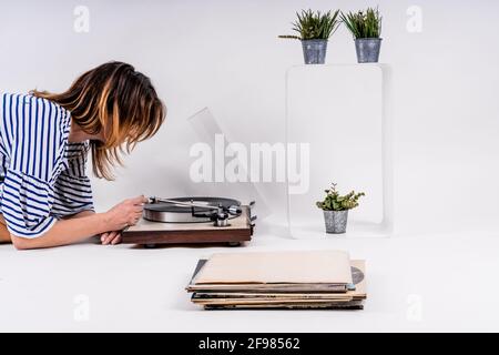 Femme vêtue de bleu et blanc robe rayée musique de mise en vinyle Banque D'Images
