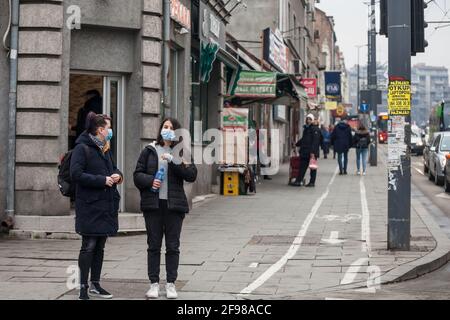 BELGRADE, SERBIE - 20 FÉVRIER 2021: Flou sélectif sur deux filles, jeunes femmes, amis, marchant en hiver en portant un masque respiratoire dans le astre Banque D'Images