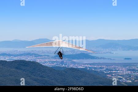 Photo aérienne d'un homme avec un deltaplane motorisé survolant la vallée sur fond de chaîne de montagnes Banque D'Images