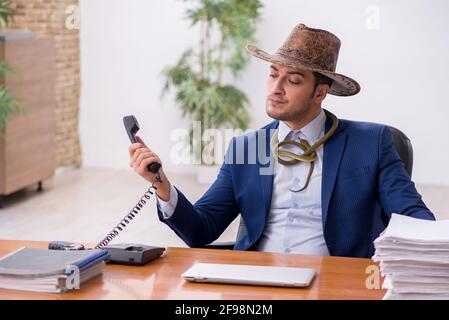 Jeune cowboy travaillant sur le lieu de travail Banque D'Images