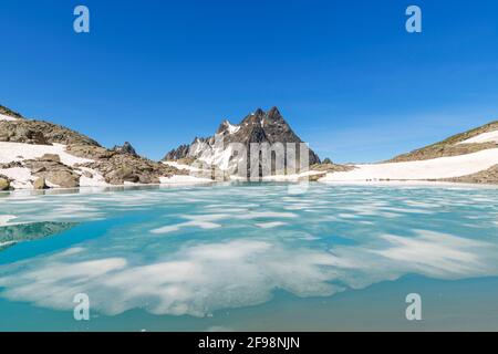 Dégeler le lac de montagne avec des flotteurs de glace en été sous un ciel bleu près de Saint Anton am Arlberg. Patteriol en arrière-plan. Verwall, Tyrol, Autriche Banque D'Images