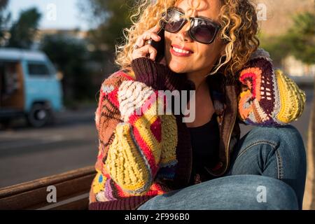 Portrait d'une femme joyeuse et heureuse faisant un appel téléphonique journée ensoleillée activités de loisirs en plein air seul - concept de joyeuse jolie femme en été style de vie de printemps souriant Banque D'Images