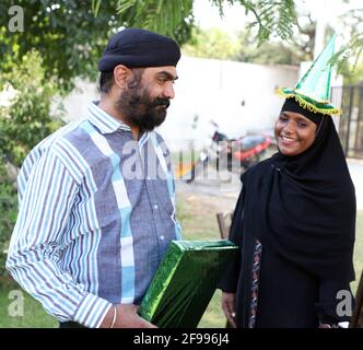 Un Indien heureux tenant son cadeau magnifiquement emballé célébrant son anniversaire avec sa famille Banque D'Images