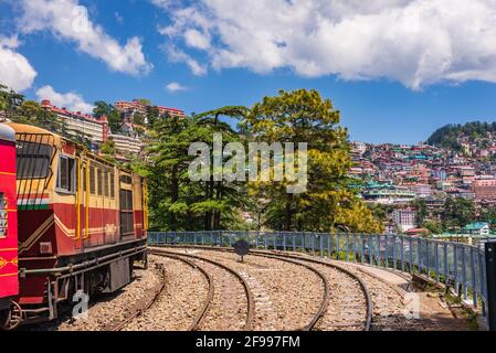 Toy train Kalka-Shimla route, debout sur la gare de Shimla avec la ville en arrière-plan. Shimla est la capitale de l'État et la destination des vacances touristiques dans le TH Banque D'Images