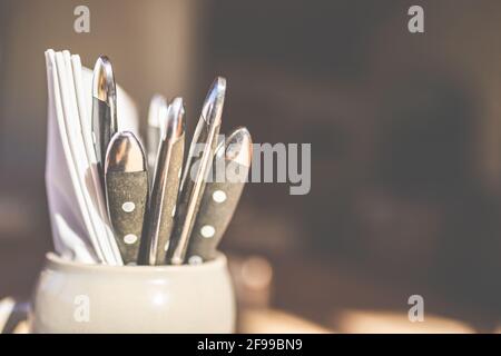 Des couverts dans une tasse à bière attendent les clients pour manger dans un restaurant. Banque D'Images