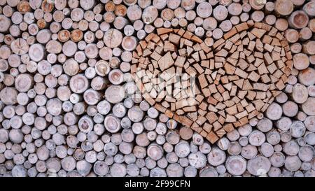 Un coeur en bois empilé dans une pile de bois de chauffage pour la cheminée ou poêle à bois. Banque D'Images