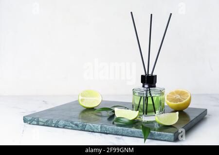 Diffuseur en roseau avec citron et lime sur fond clair Banque D'Images