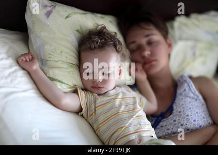 La famille dormait sur un lit à la maison dans le matin Banque D'Images