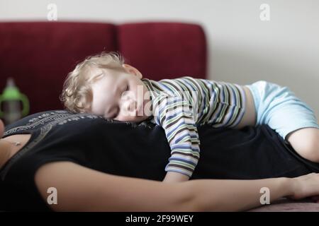 L'enfant dort sur sa mère à la maison Banque D'Images