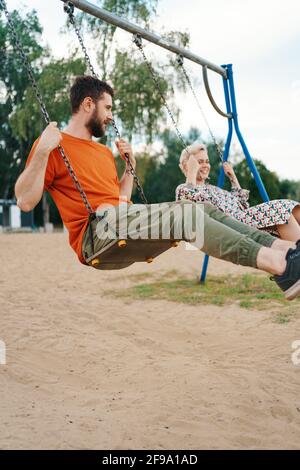 Un couple romantique s'amuse à l'extérieur. Profiter de passer du temps ensemble sur une balançoire. Banque D'Images