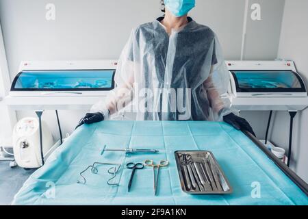 Table de préparation du personnel infirmier avec jeu d'instruments chirurgicaux stériles pour une chirurgie dentaire Banque D'Images