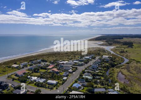 Photo aérienne de la plage d'Otaki avec le village, les forêts et les terres agricoles en premier plan, par une journée ensoleillée Banque D'Images