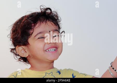 Portrait en gros plan à angle bas d'un enfant indien souriant yeux fermés Banque D'Images