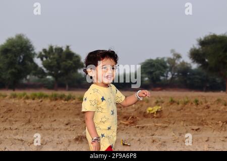 Portrait en gros plan à angle bas d'un enfant indien le champ regardant la caméra Banque D'Images