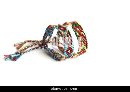 Bracelets de bricolage avec motif indien coloré fait à la main de fil sur fond blanc Banque D'Images