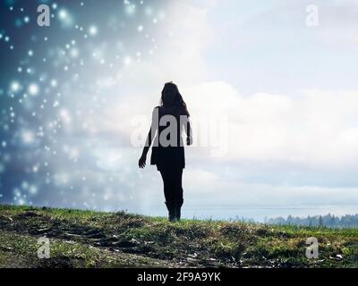 Jeune femme avec de longs cheveux dans le temps change de averses de neige au soleil Banque D'Images