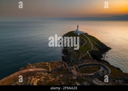 Phare de South Stack sur un petit promontoire à la lumière de coucher de soleil Banque D'Images