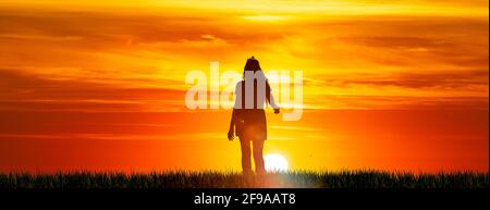 Silhouette d'une femme aux cheveux longs avant le coucher du soleil Banque D'Images