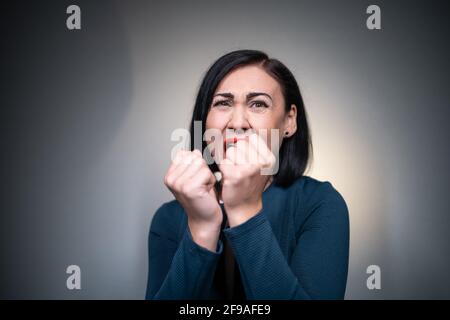studio photo de femme brune peur ou peur sur gris arrière-plan Banque D'Images