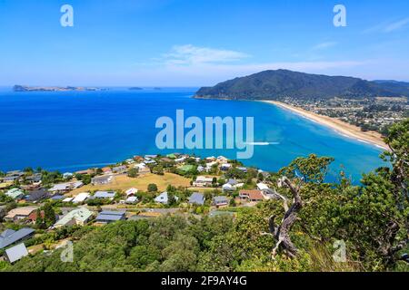 Les villes côtières voisines de Tairua (premier plan) et Pauanui sur la pittoresque péninsule de Coromandel, Nouvelle-Zélande. En mer se trouve l'île de Slipper, une station balnéaire Banque D'Images