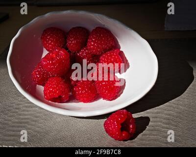 Framboises dans un bol blanc Banque D'Images