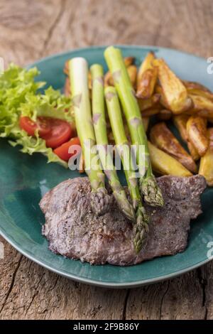 asperges sur un steak grillé avec des frites Banque D'Images