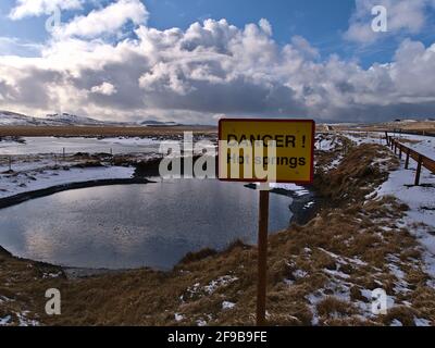 Panneau d'avertissement jaune (danger) devant les sources d'eau chaude dans la zone géothermique de Seltún, faisant partie du système volcanique Krýsuvík, sur Reykjanes, Islande. Banque D'Images