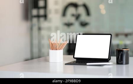 Maquette de tablette numérique avec écran blanc vierge sur le lieu de travail au bureau. Banque D'Images