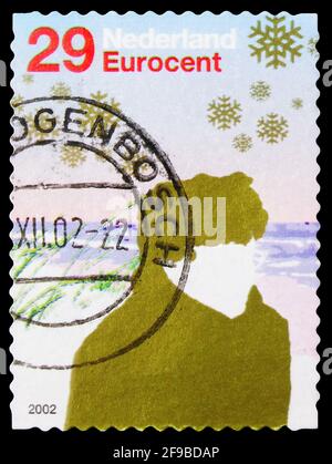 MOSCOU, RUSSIE - 24 SEPTEMBRE 2019: Timbre-poste imprimé aux pays-Bas spectacles personnes en paysage d'hiver, série de timbres de décembre, vers 2002 Banque D'Images