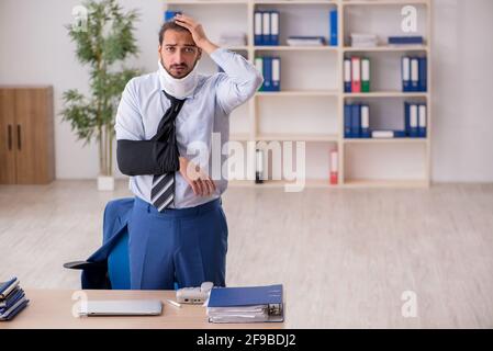 Jeune homme employé après un accident travaillant dans le bureau Banque D'Images