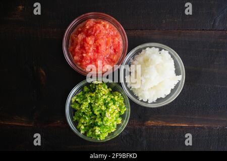 Bols de légumes en purée sur une table en bois : oignons en purée, tomates, piments verts, gingembre et ail Banque D'Images