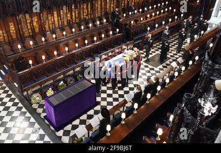La reine Elizabeth II observe que les pallbearers portent le cercueil du duc d'Édimbourg lors de ses funérailles à la chapelle St George, au château de Windsor, dans le Berkshire. Date de la photo: Samedi 17 avril 2021. Banque D'Images