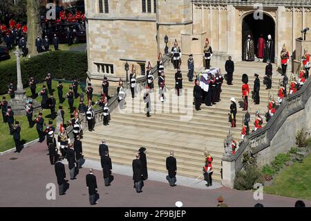 Le cercueil du duc d'Édimbourg, couvert de son standard personnel, est porté à l'entrée de la chapelle comme la princesse Royale, le prince de Galles, le duc d'York, le comte de Wessex, le duc de Cambridge, Peter Phillips, le duc de Sussex, Le comte de Snowdon et le vice-amiral Sir Timothy Laurence attendent au pied des marches de la chapelle St George, château de Windsor, Berkshire, devant les funérailles du duc d'Édimbourg. Date de la photo: Samedi 17 avril 2021. Banque D'Images