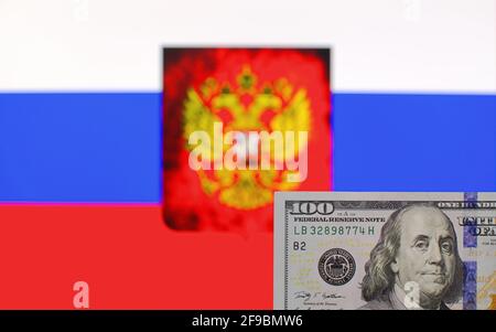 100 billets de banque en dollars US gros plan sur un fond flou de Drapeau et blason de la Fédération de Russie Banque D'Images