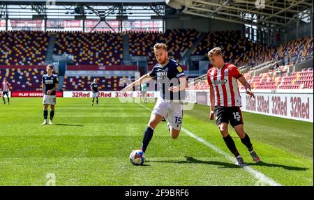 Londres, Royaume-Uni. 17 avril 2021. Alex Pearce de Millwall avec le ballon suivi par Marcus Forss de Brentford FC lors du match de championnat EFL Sky Bet entre Brentford et Millwall au stade communautaire de Brentford, Londres, Angleterre, le 17 avril 2021. Photo de Phil Hutchinson. Utilisation éditoriale uniquement, licence requise pour une utilisation commerciale. Aucune utilisation dans les Paris, les jeux ou les publications d'un seul club/ligue/joueur. Crédit : UK Sports pics Ltd/Alay Live News Banque D'Images