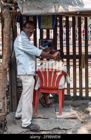 Un barbershop de rue à côté de la gare de Dadar à Mumbai, Maharashtra, Inde, Asie. Banque D'Images