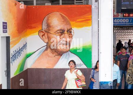 Commuter marchant au-delà d'une image de Mahatma Gandhi à l'intérieur de la gare de Dadar à Mumbai, Maharashtra, Inde, Asie. Banque D'Images