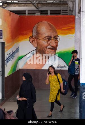 Commuter marchant au-delà d'une image de Mahatma Gandhi à l'intérieur de la gare de Dadar à Mumbai, Maharashtra, Inde, Asie. Banque D'Images