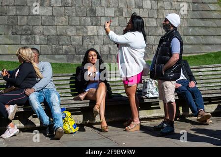 Windsor, Royaume-Uni. 17 avril 2021. Personnes sur des bancs à l'extérieur du château de Windsor pendant un silence de 2 minutes le jour des funérailles du prince Philip, décédé le 9 avril, âgé de 99 ans. Les restrictions en cas de pandémie du coronavirus ont limité le nombre de personnes qui se sont garantes à 30 membres de la famille proche lors des funérailles de 15 h au château de Windsor. Credit: Stephen Chung / Alamy Live News Banque D'Images