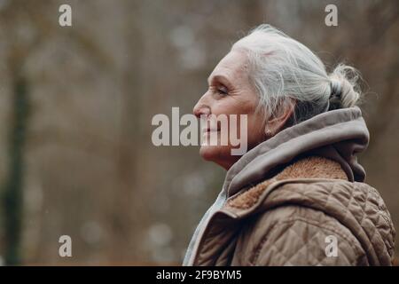 Portrait d'une femme âgée souriante aux cheveux gris en plein air Banque D'Images