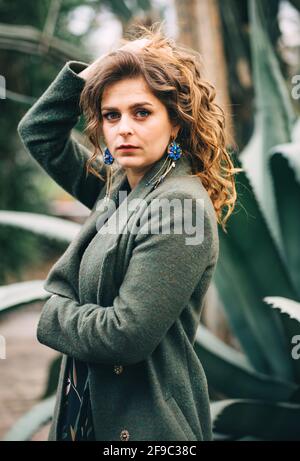 fille dans un manteau vert avec de belles boucles d'oreilles Banque D'Images