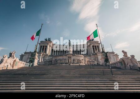 Monument Vittorio Emanuele sur la Piazza Venezia, Rome, Italie. Journée ensoleillée, nuages doux, deux drapeaux italiens. Escalier en premier plan Banque D'Images