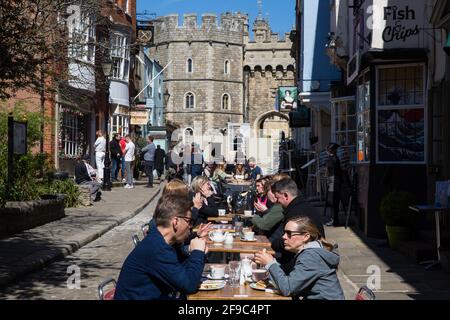 Windsor, Royaume-Uni. 17 avril 2021. Les visiteurs s'assoient à des tables devant un restaurant près du château de Windsor le jour des funérailles du duc d'Édimbourg. Les funérailles du prince Philip, époux de la reine Elizabeth IIÕs, ont lieu à la chapelle Saint-Georges, au château de Windsor, la cérémonie étant limitée à 30 personnes, conformément aux restrictions actuelles relatives au coronavirus. Crédit : Mark Kerrison/Alamy Live News Banque D'Images