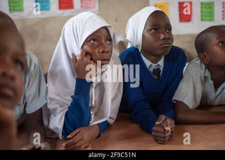 Dodoma, Tanzanie. 08-18-2019. Portrait de deux belles filles musulmanes à l'écoute de leur professeur donnant une conférence à l'intérieur de la salle de classe avec d'autres stude Banque D'Images