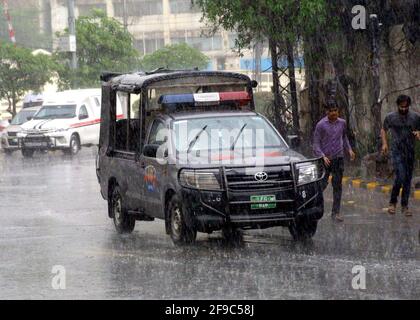 Les navetteurs qui passent par la route pendant une grosse descente à Lahore le samedi 17 avril 2021. Banque D'Images