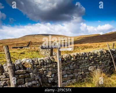 De vieilles enseignes en bois et un mur en pierre sèche pointent vers le chemin au-dessus des montagnes. Réservoir de la maison de cicatrice. Niddoyre. Yorkshire Dales Banque D'Images