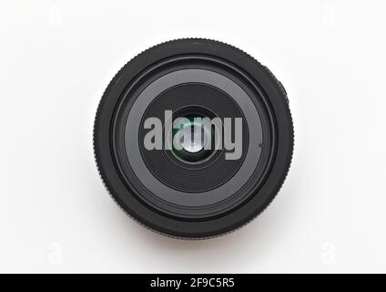 Petit objectif noir fin de 24 mm pour un appareil photo reflex numérique sans nom sur fond blanc sans couvercle. Vue rapprochée du dessus Banque D'Images